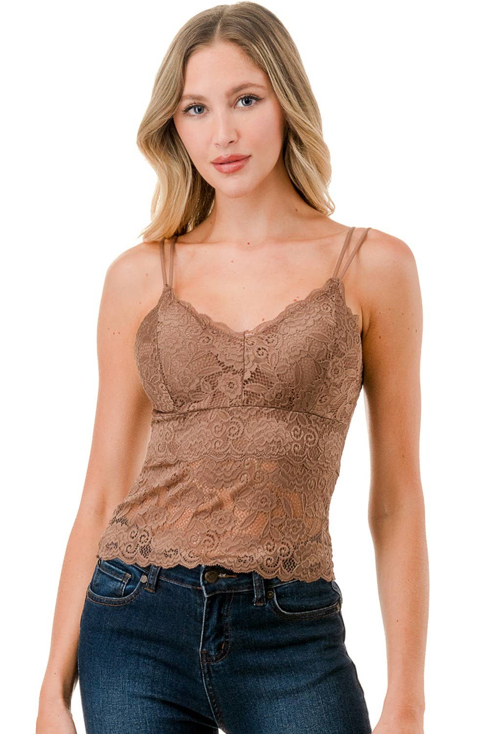 Woman wearing a brown lace camisole and blue jeans on a white background