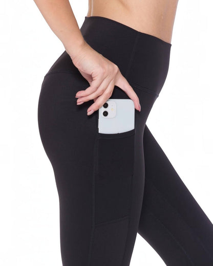 Black leggings with a pocket holding a phone on a white background