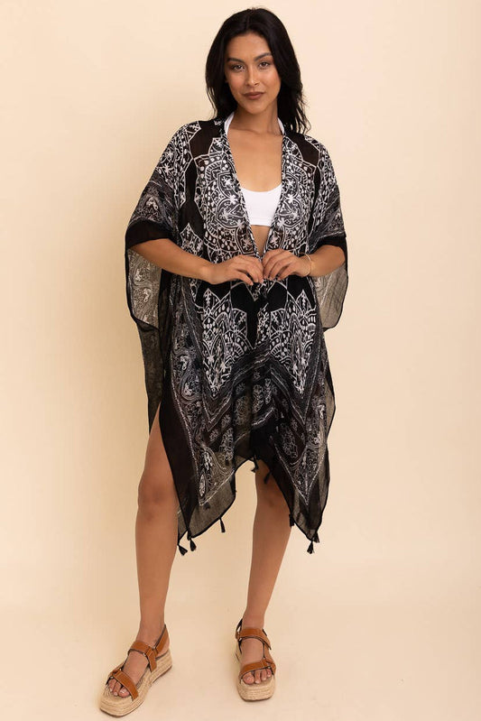 Woman wearing a black patterned kimono-style garment on a beige background