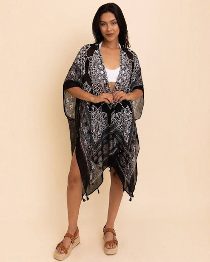 Woman wearing a black patterned kimono-style garment on a beige background