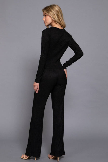 Woman wearing a black outfit against a gray background