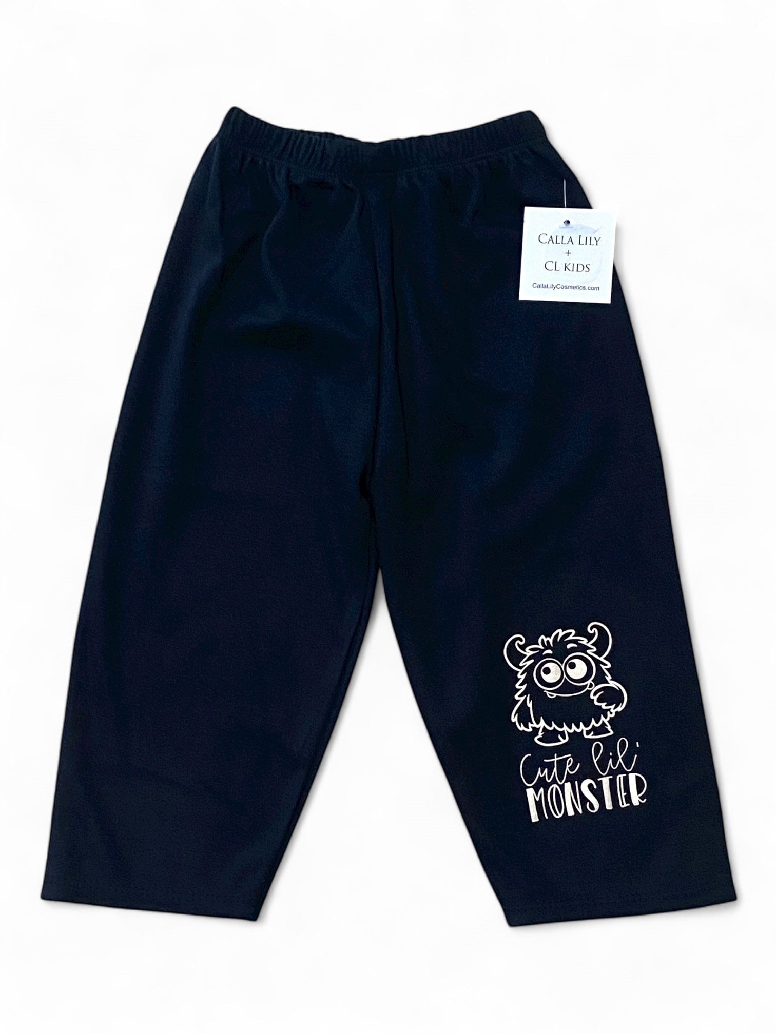 Black children's pants with a white monster design and text on a white background