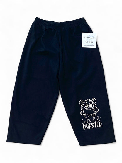 Black children's pants with a white monster design and text on a white background