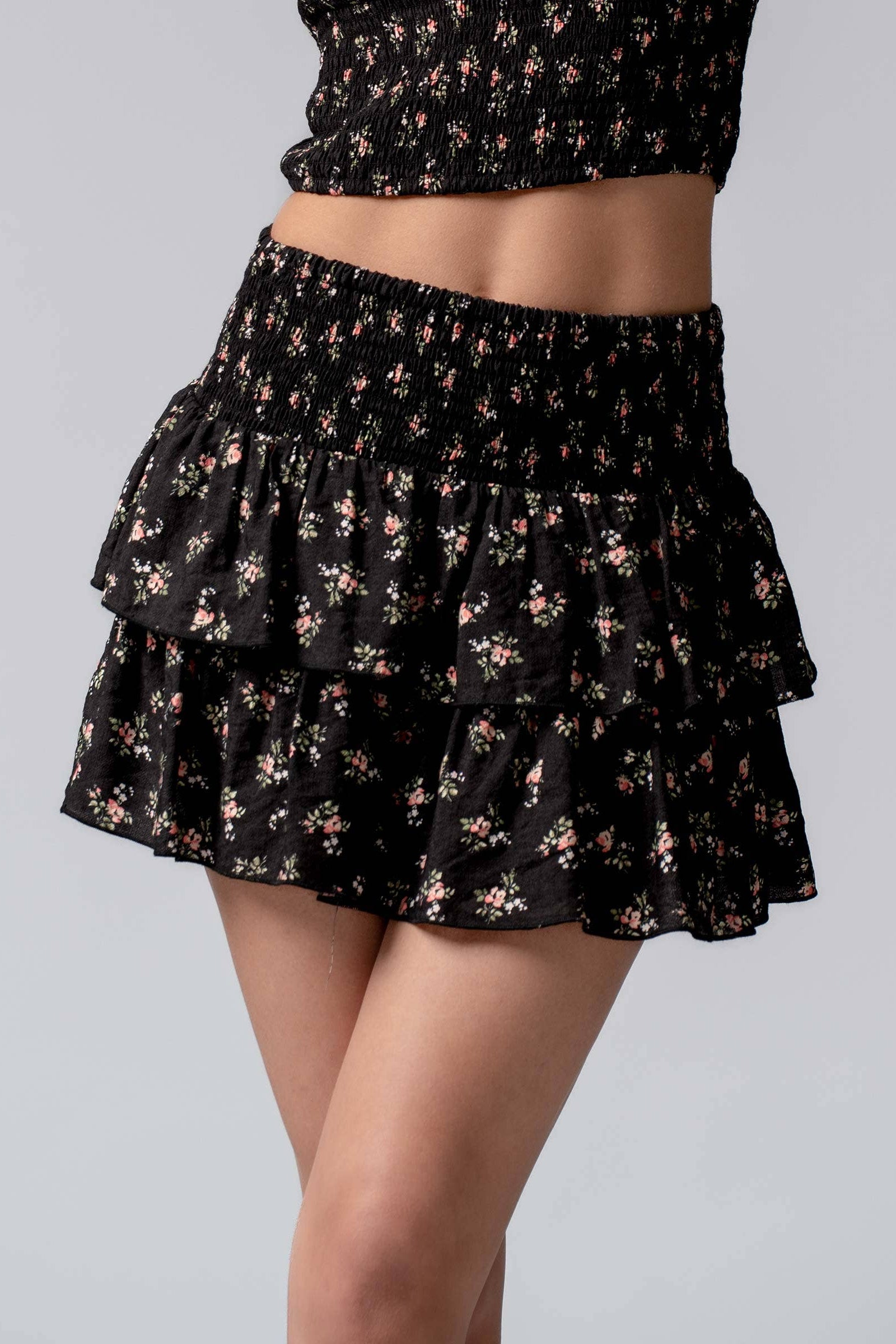 Black floral skirt with ruffled layers on a gray background