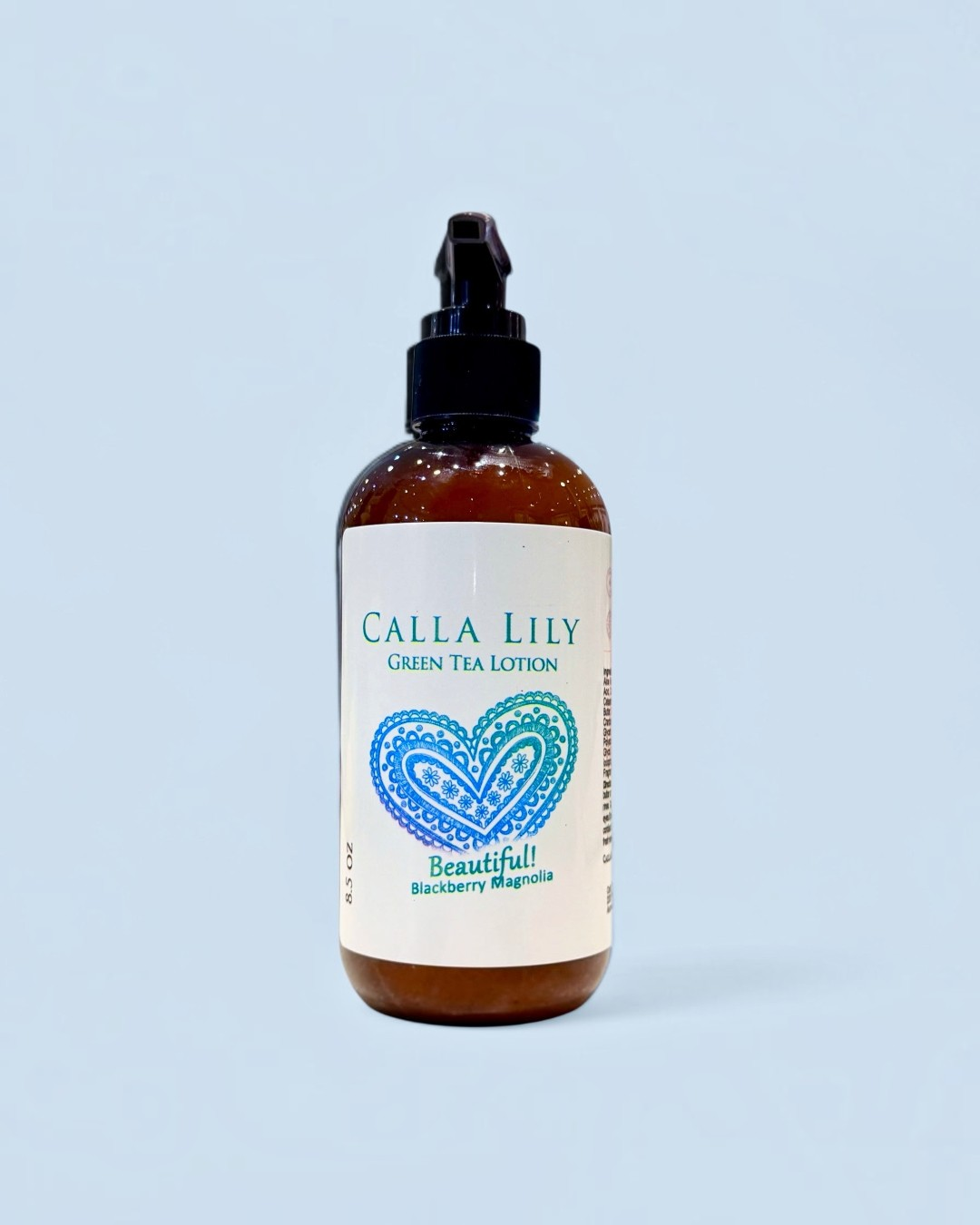 Calla Lily green tea lotion bottle with a heart design on a light blue background. Blackberry Magnolia Cream Lotion