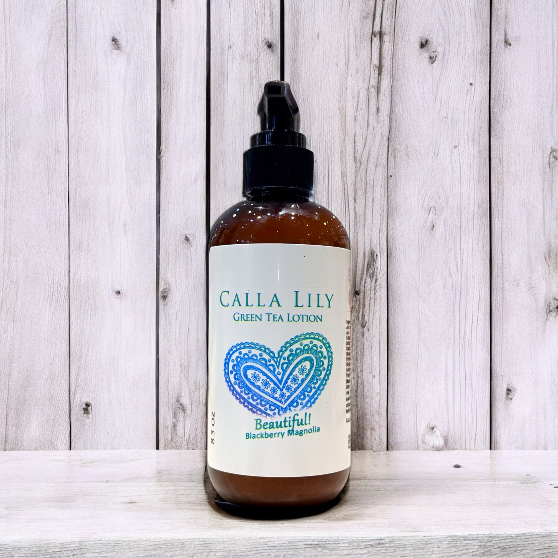 Bottle of Calla Lily Green Tea Lotion on a wooden surface. Blackberry Magnolia Cream Lotion