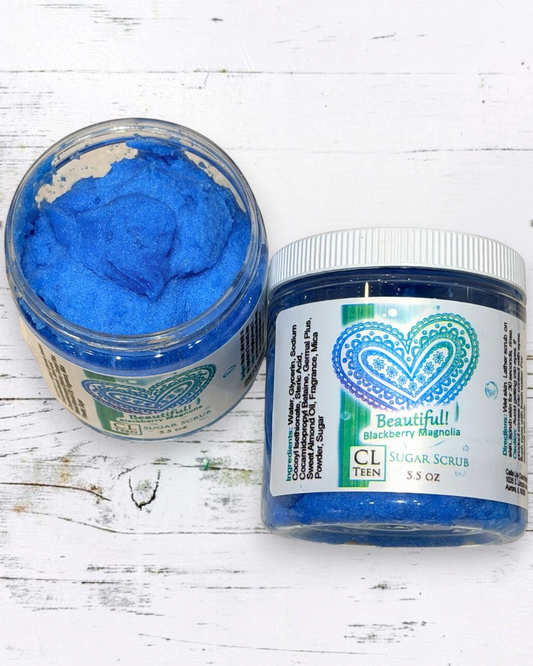 Two jars of blue sugar scrub with visible brand labels on a white surface.