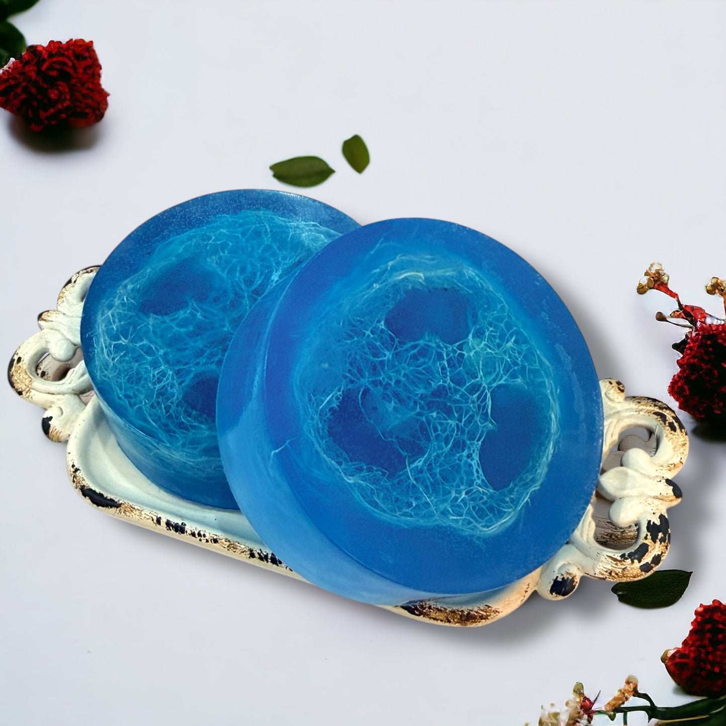 Two blue soaps on a decorative tray with floral elements