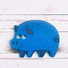 Blue pig-shaped object on a white wooden surface