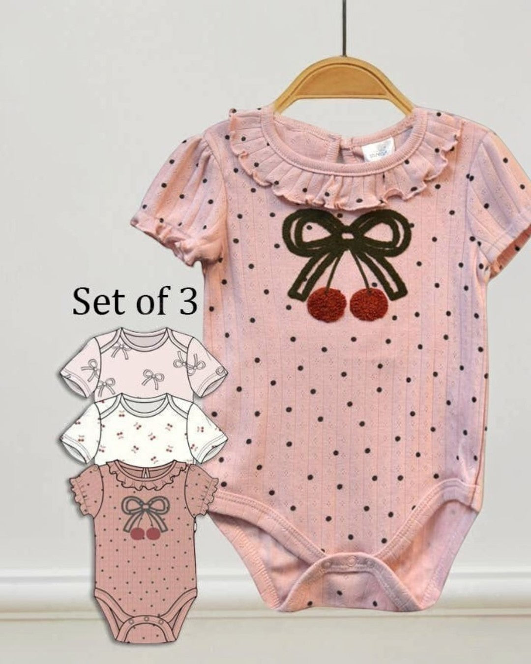 Set of three baby rompers with polka dot design and bow details on a white background.