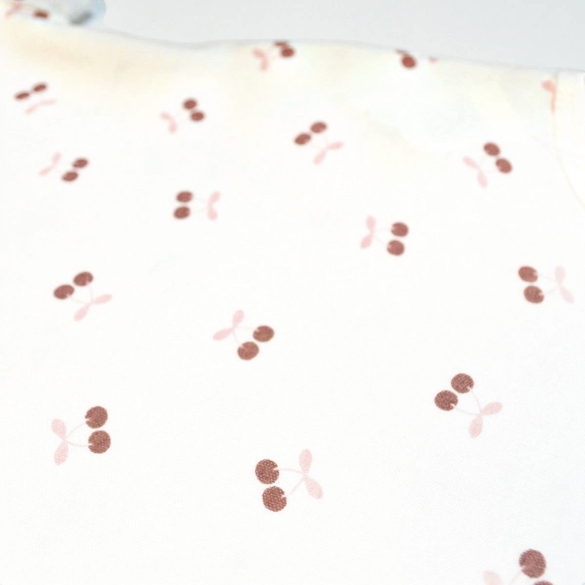 Pattern of red and pink cherries on a white background