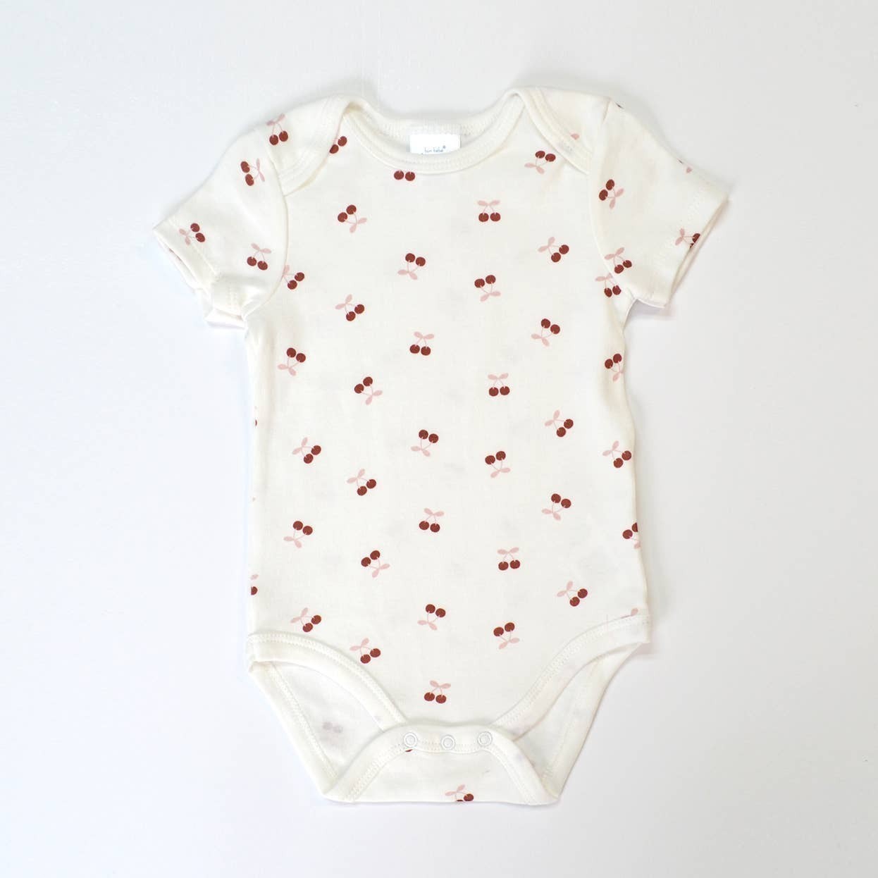 Baby onesie with cherry pattern on a white background
