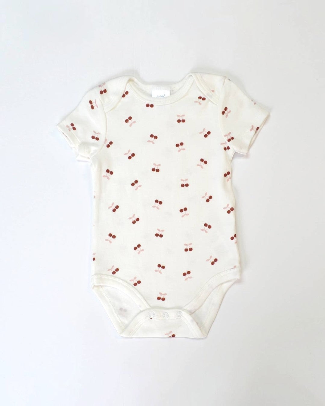 Baby onesie with cherry pattern on a white background
