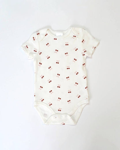 Baby onesie with cherry pattern on a white background