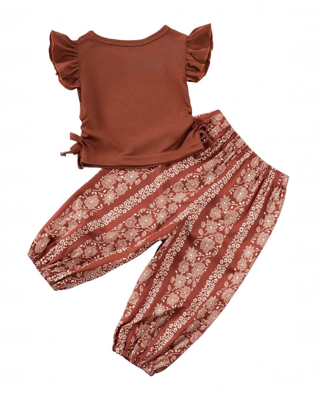 Brown top and floral pants set on a white background with yellow flowers.