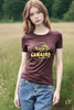 Person wearing a brown t-shirt with yellow text and graphics in a field