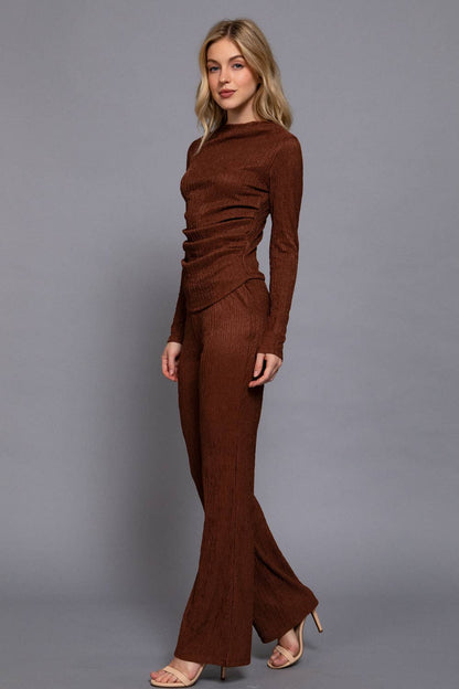 Woman wearing a brown outfit against a gray background