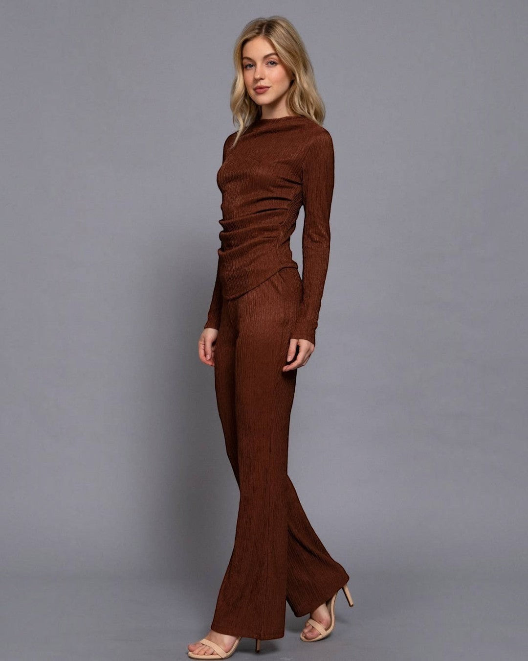 Woman wearing a brown outfit against a gray background