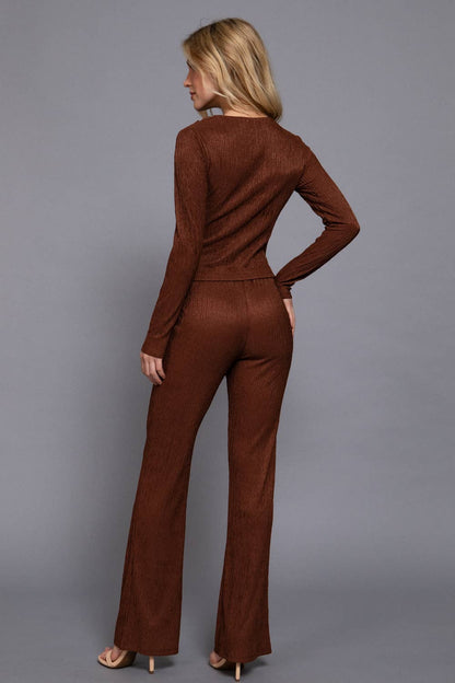 Woman wearing a brown jumpsuit against a gray background