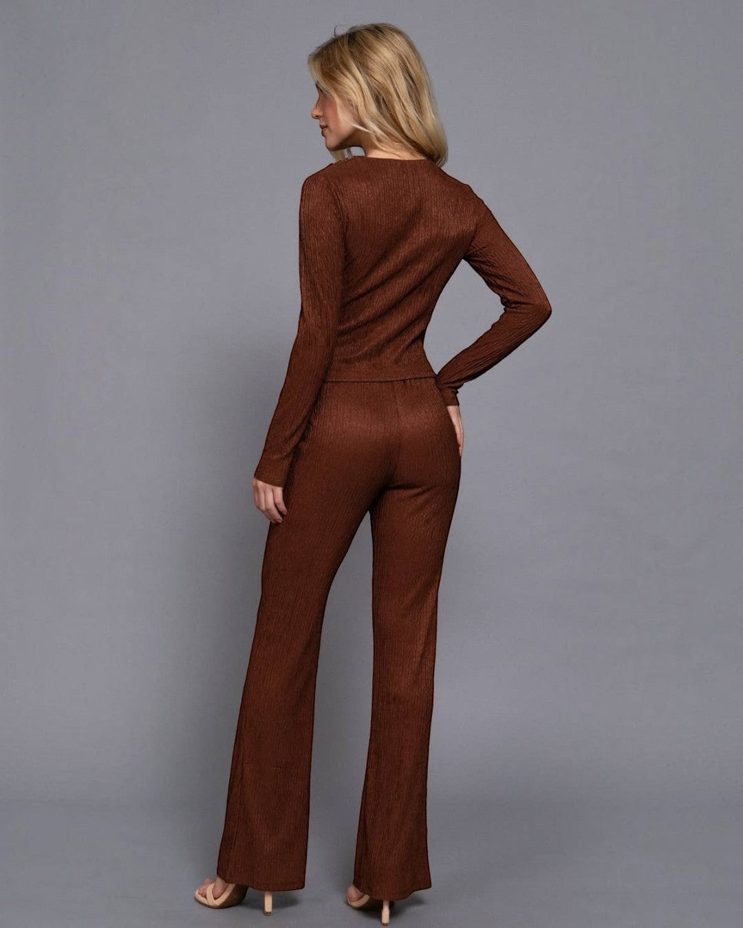 Woman wearing a brown jumpsuit against a gray background