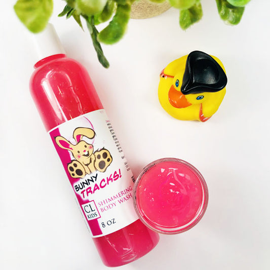 Bunny Tracks Shimmering Body Wash in a transparent bottle and cup of our pink bunny tracks body wash against a white background