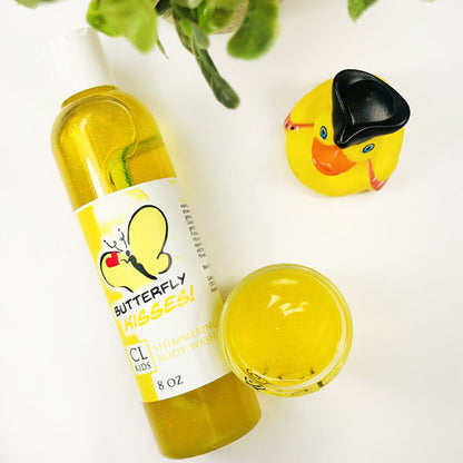 Butterfly Kisses Shimmering Body Wash in a transparent bottle and cup of our yellow butterfly kissses body wash against a white background