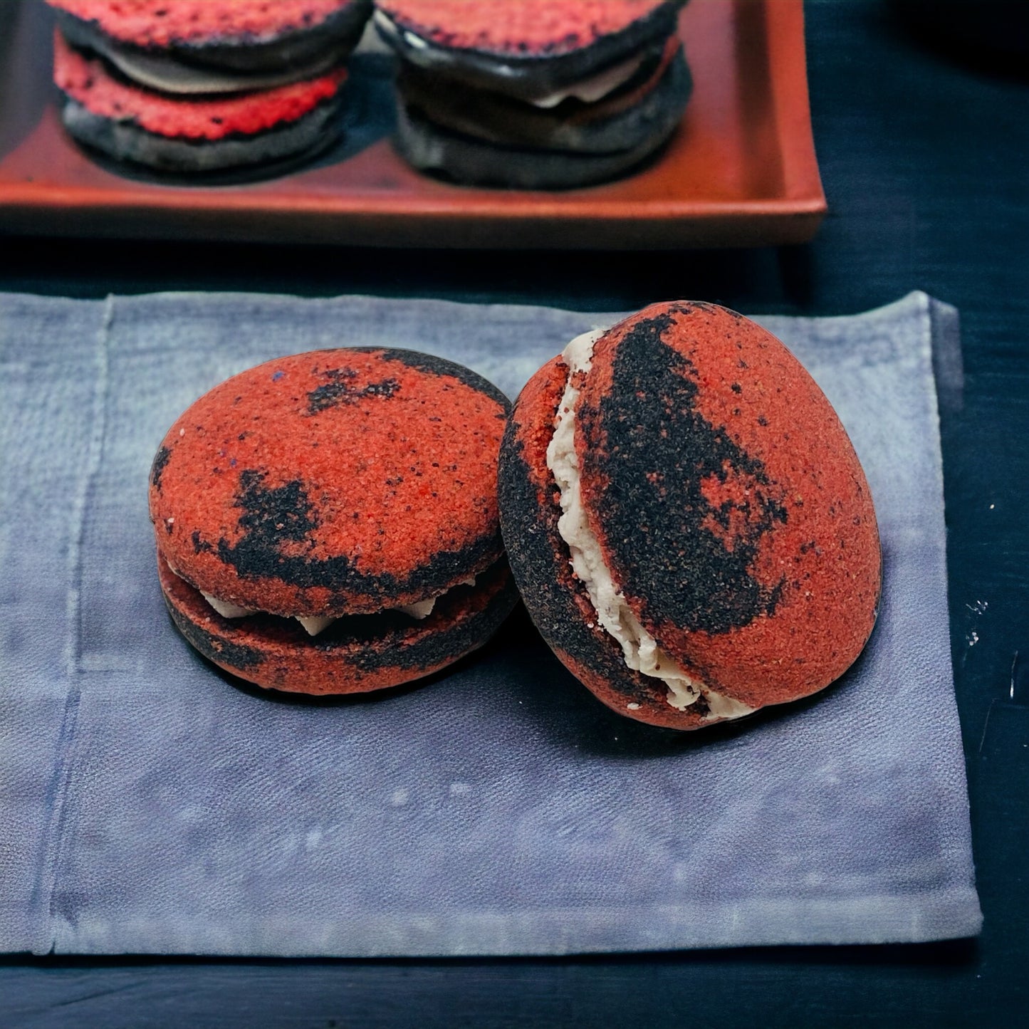 Two red and black dragons blood bath cookies on a piece of fabric