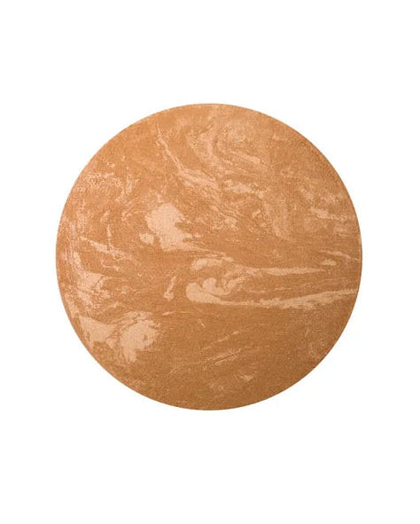 Round bronze-colored makeup product on a white background