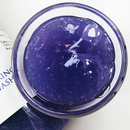 A cup of our purple unicorn yawns body wash against a white background