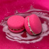 Two pink piggy snorts bath cookies against a glittery pink background