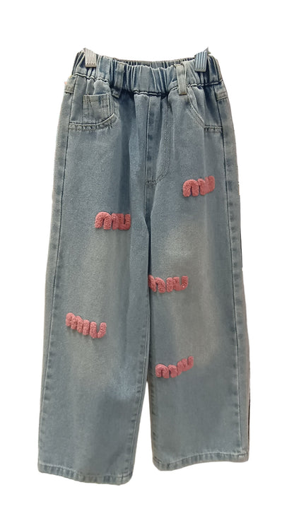 Blue jeans with pink text patches on a white background