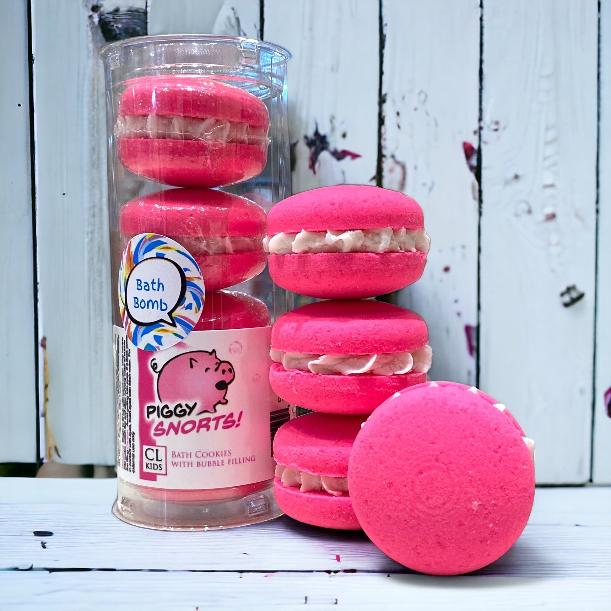 A stack and tube of pink piggy snorts bath cookies against a wood background