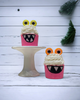 Calla Lily Cosmetics + CL kids pink monster bath bombs with bubble icing and googly eyes on a white cake stand