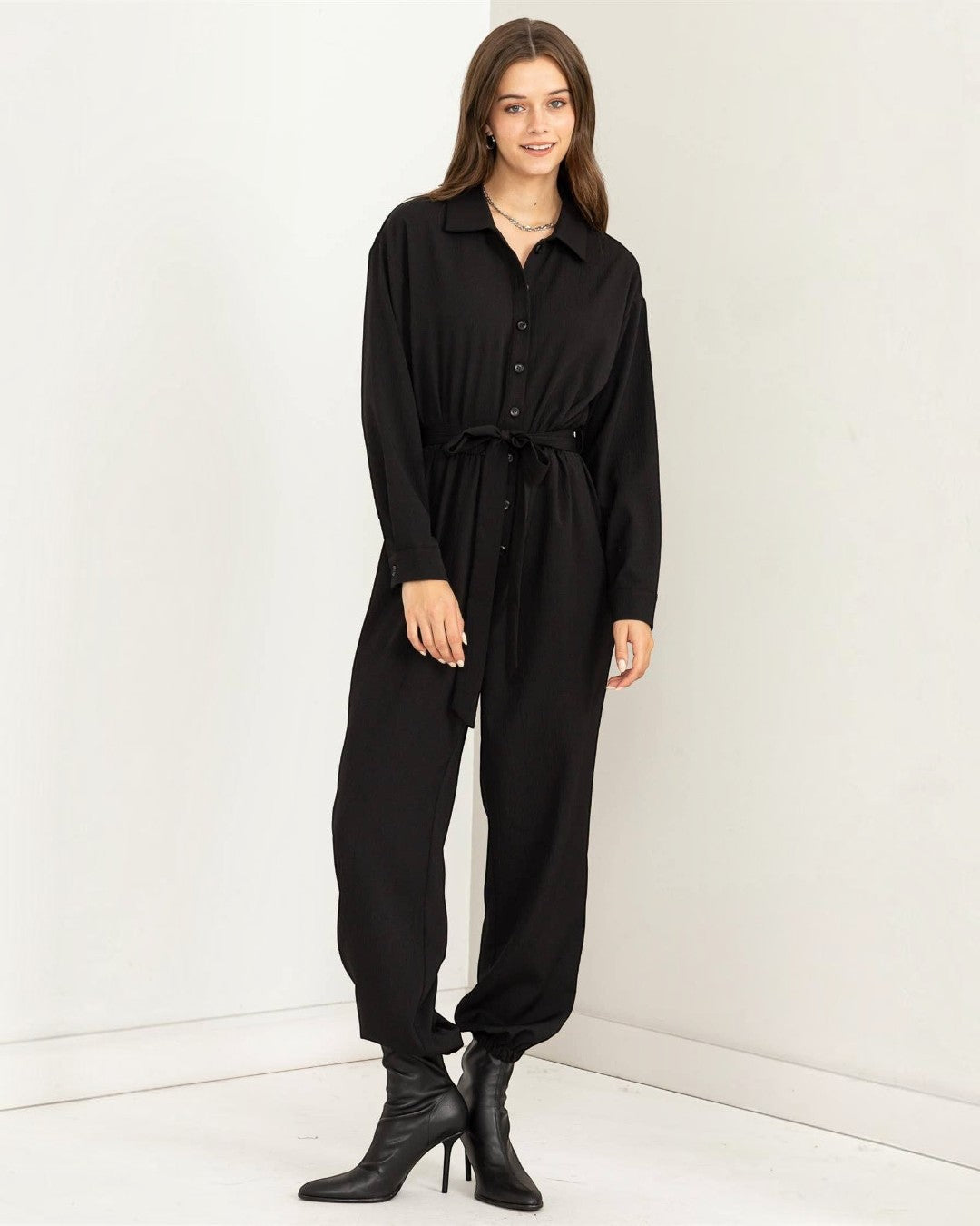 Woman wearing a black jumpsuit on a white background