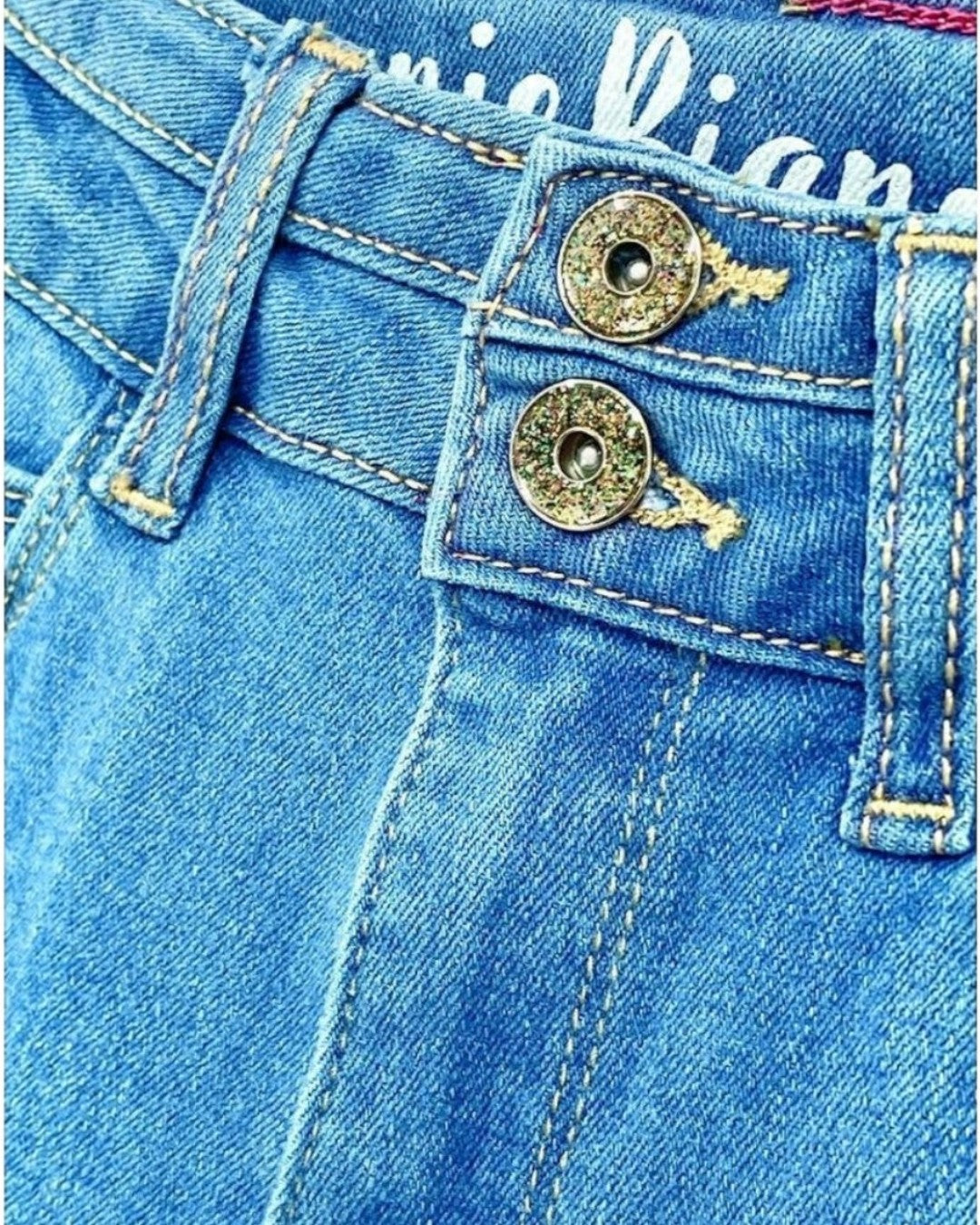 Close-up of blue denim jeans with brand name on pocket