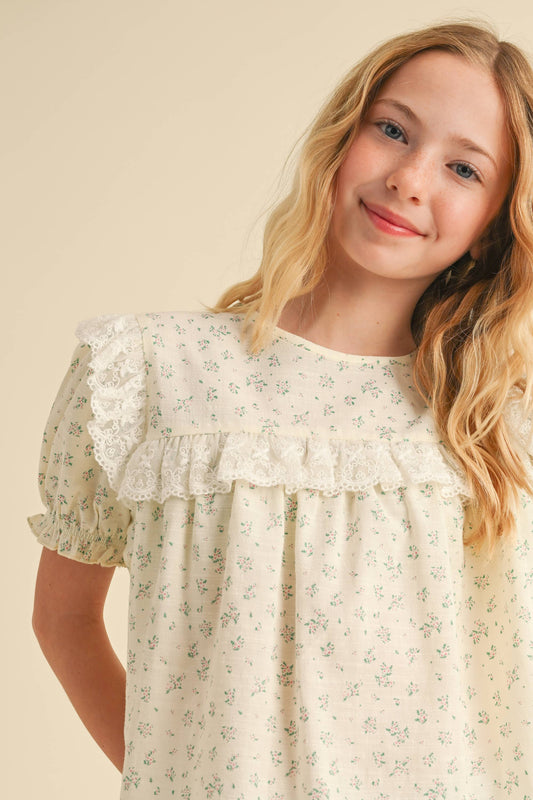Young girl wearing a floral dress against a beige background