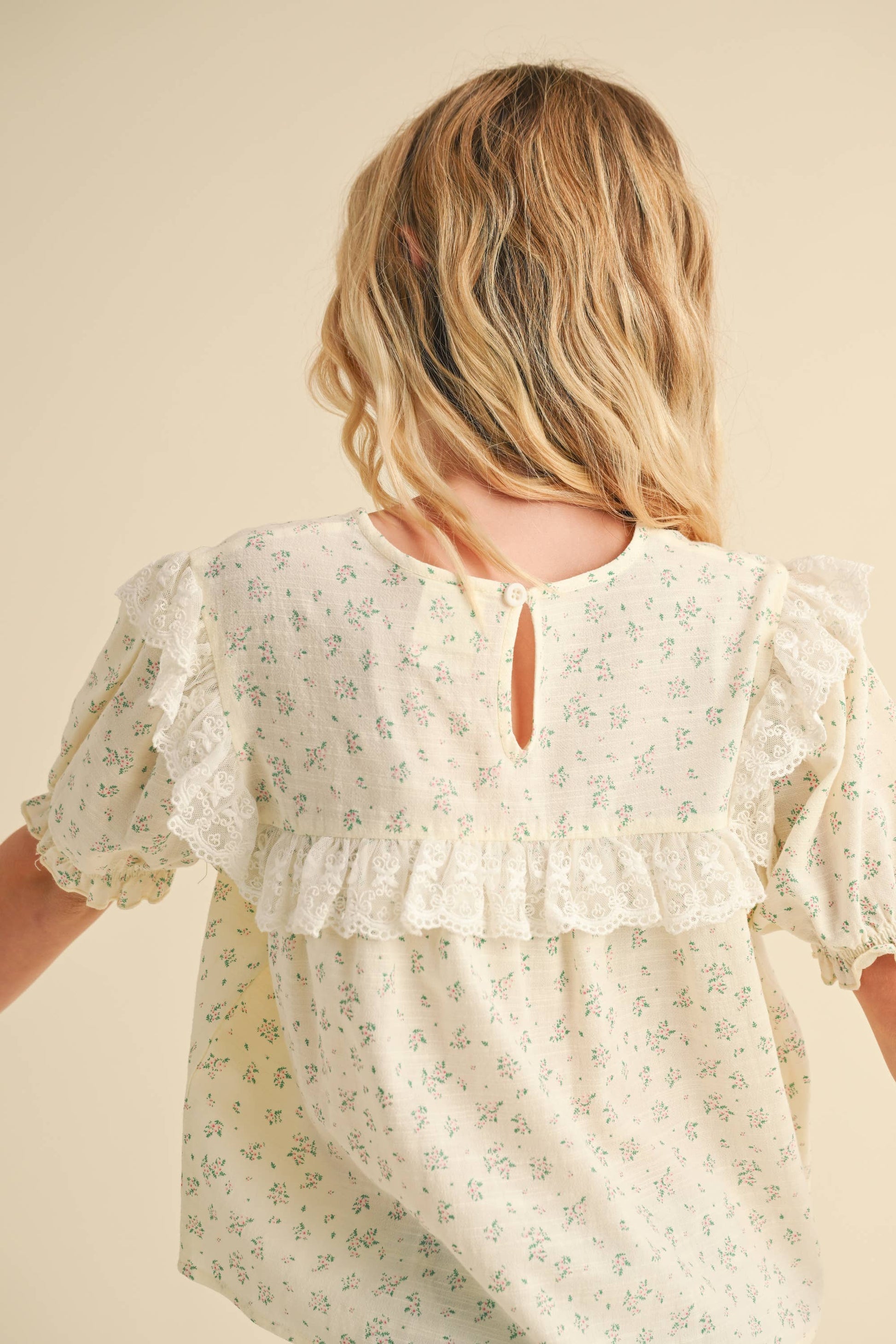 Woman wearing a floral blouse with a neutral background