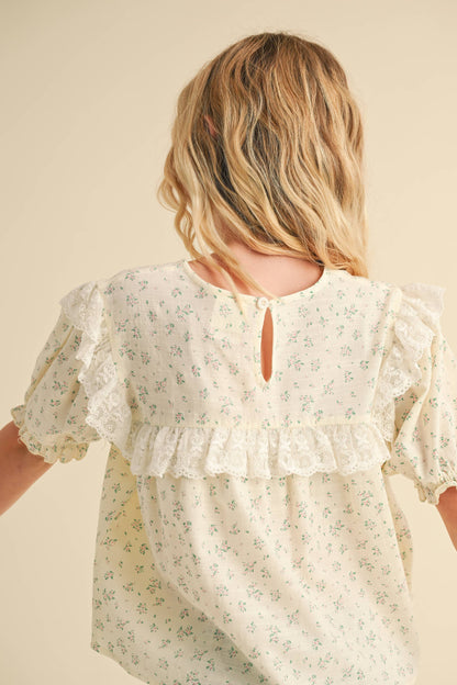 Woman wearing a floral blouse with a neutral background