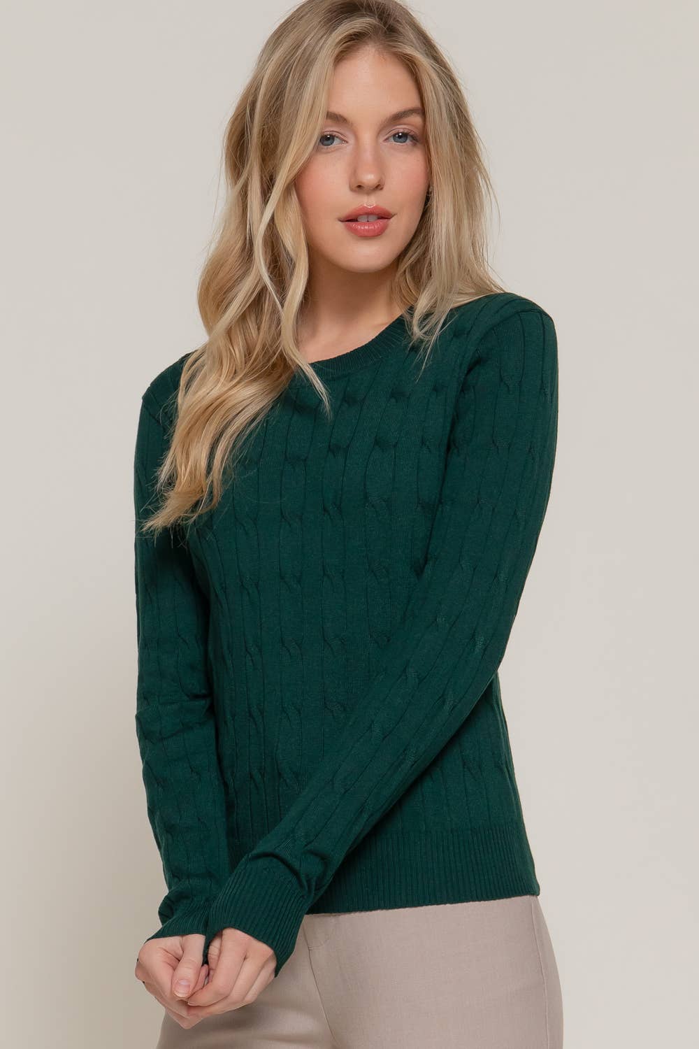 Woman wearing a green sweater against a plain background