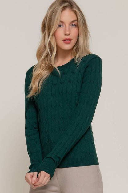 Woman wearing a green sweater against a plain background