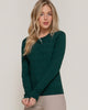 Woman wearing a green sweater against a plain background