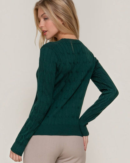 Woman wearing a green sweater against a plain background