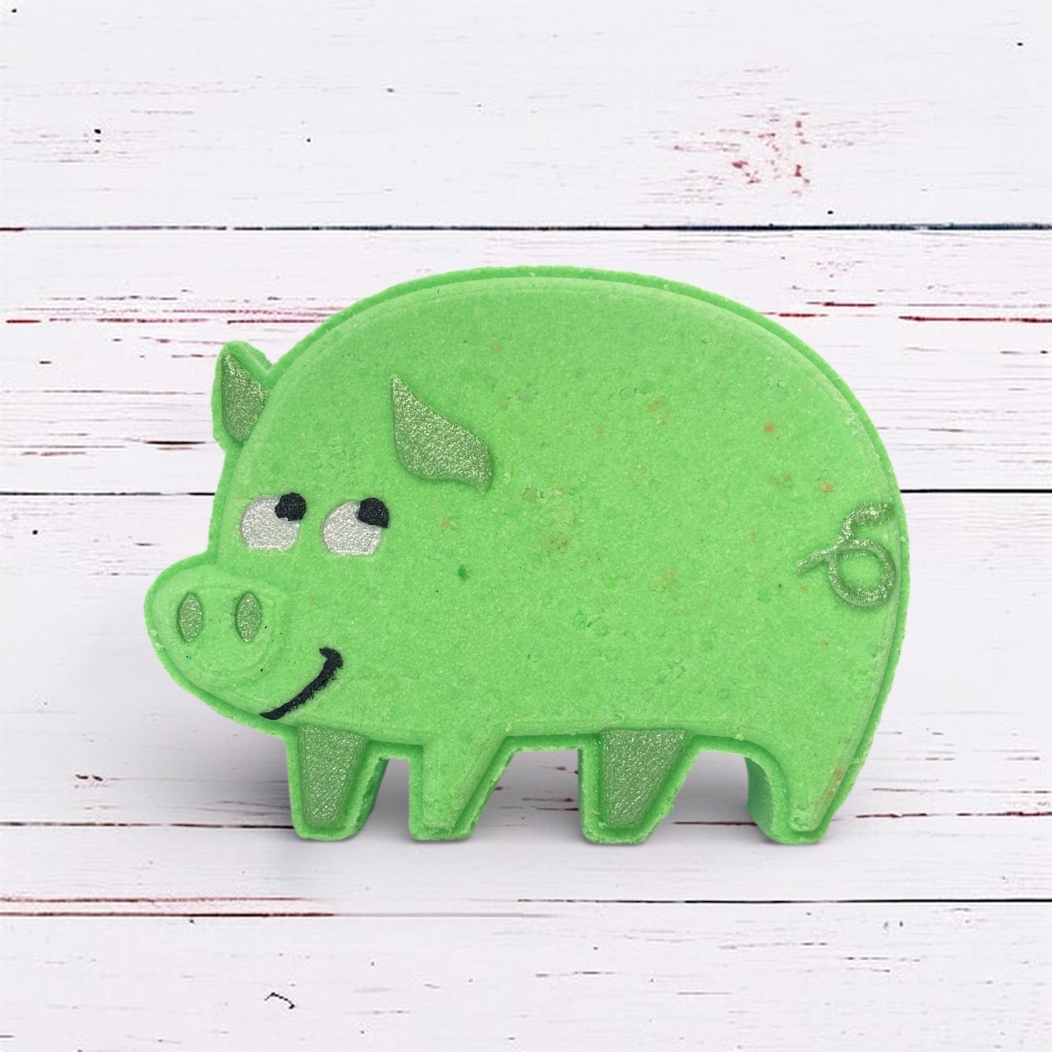 Green pig-shaped object on a white wooden surface