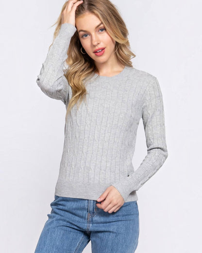 Woman wearing a gray sweater and blue jeans on a white background