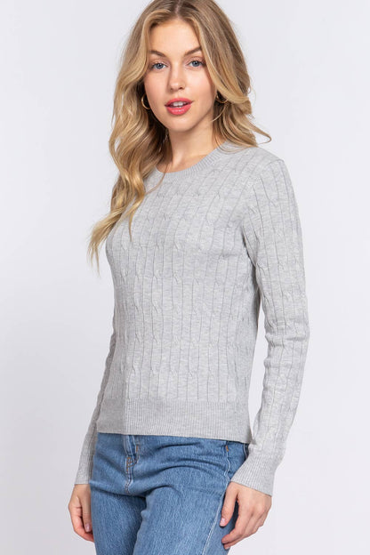 Woman wearing a gray sweater and blue jeans on a white background