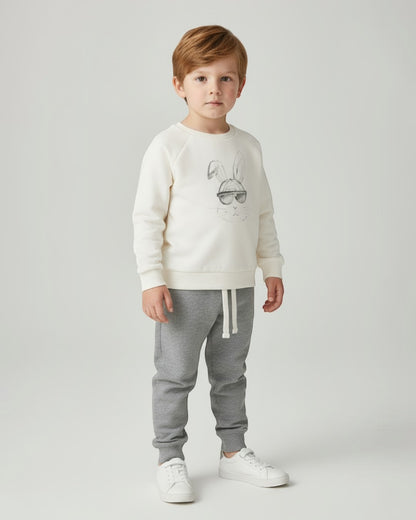 Children's outfit with cream sweatshirt and gray jogger pants on a white background