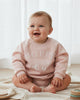 Pink sweatshirt with 'HOPPY' text on a white background
