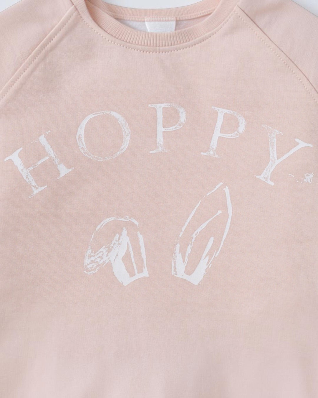 Pink sweatshirt with 'HOPPY' printed in white on a light pink background