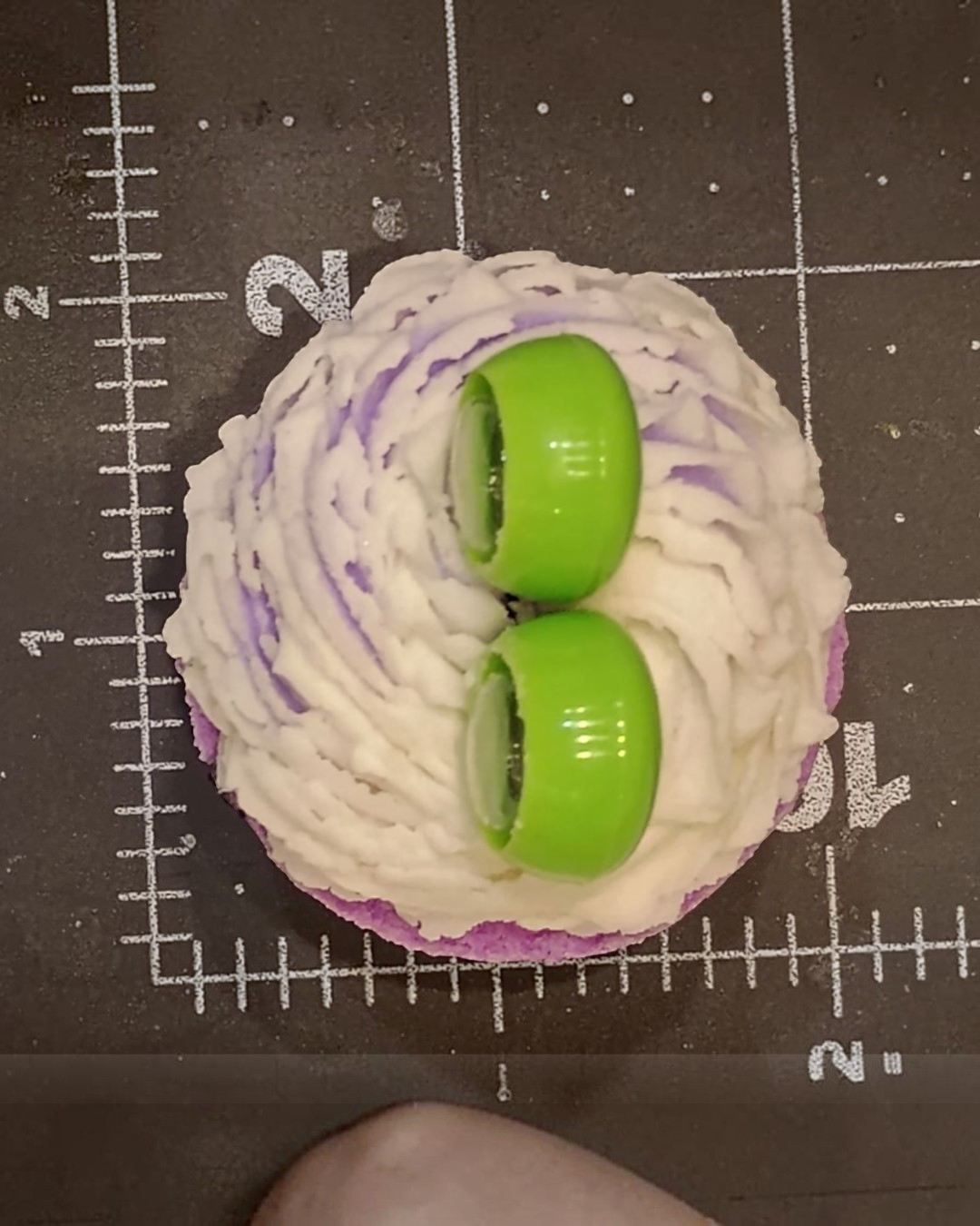 Calla Lily Cosmetics + CL kids purple grape scented monster bath bomb with white icing and green googly eyes