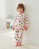 Child wearing a colorful pajama set with various patterns in a room.